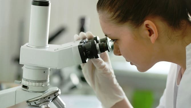 Врач смотрит в микроскоп